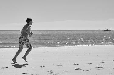 Boy running at the beach thumb