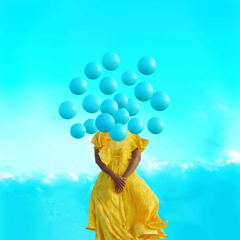 An art photograph by Fares Miscue. It has a blue background, a woman with a yellow dress, and blue balls floating all around her, obscuring her face.
