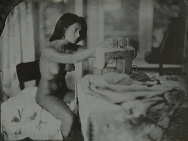 naked girl sews on a sewing machine thumb