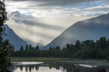 Bright contrast rays of morning sun over the Lake Matheson thumb