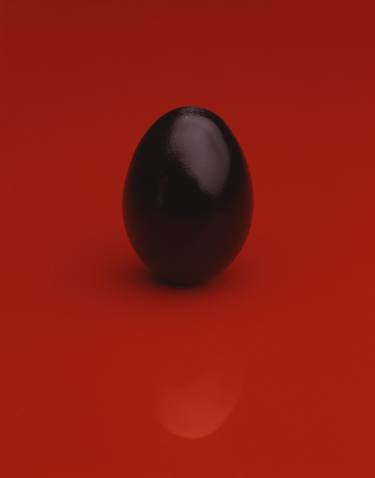 black egg on red thumb
