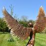 Icarus IX bronze sculpture in a garden setting.