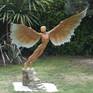 Bronze sculpture of Icarus in garden.