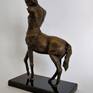 A brass sculpture of a mythical centaur standing tall.