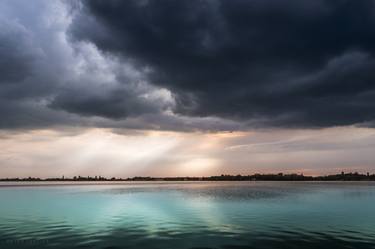 Turquoise lake under the cloudy sky thumb