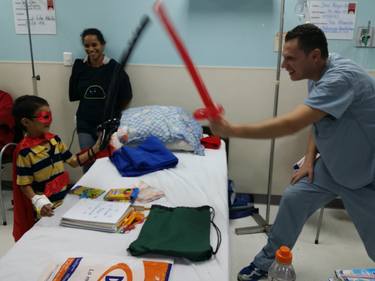 Dr Schow making balloon swords and playing with patients in a children’s cancer hospital thumb