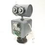 Found Objects Robot Sculpture / Assemblage Robot Figurine - One of a kind unique creation - Unique Gift
Most of my found object robot parts are found in flea markets, thrift stores, and auctions.
This unique robot is made with as listed;
( Head ) Tin, painted with a dark gray paint. The paint is hand-painted on and does contain brush stokes.
( Eyes ) Round plastic pieces with washers and bolts.
( Antenna ) cotter pin screwed to computer circuitry and then to the tin head.
( Neck ) 2 Hex Nuts and washers bolted to the body and head.
( Body ) Metal Tin Painted with a Dark gray paint with circuitry board components screwed and glued on. The paint is hand-painted on and does contain brush stokes.
( Arms / Hands). Power plug ins cords with hex nuts and glued for extra reinforcement.
( Legs ) Large Bolts with washers bolted to the the body tin.
( Feet / Support ) Washes with a coaster for the base for support
Tins are Glued Shut Permanently.
E6000 Industrial Strength Glue used.
My Robots are made with used parts and MAY but not always contain dents, dings, scratches, rust, and spots where the paint may have been chipped or scraped during assembly, and could have some glue showing where parts are attached, The paint is hand-painted on and does contain brush stokes. PLEASE see pictures for craftsmanship, condition and details, Thanks.
This robot is built as sturdy as possible, and is bolted and screwed together when possible and some parts are just glued together with E6000 Industrial Strength Glue, and so he should be handled gently and with care.
He stands approximately 12” tall, by 8” wide by 5 1/4” thick.
Add this robot to your own personal collection or buy him as a gift for someone to be used as a one of kind unique gift.
This assembled robot sculpture was built to be a fun art sculpture and is not functional. He is for decoration purposes only. He has no moving parts and is most likely NOT suitable for small children.