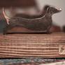 A small tabletop sculpture of a Dachshund created out of steal with a bronze and gold patina mounted on an old growth larch wooden base.