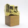 A micro sculpture in brass with gold patina on a wooden base.
Inspired from the ancient Greek drama.