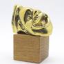 A micro sculpture in brass with gold patina on a wooden base.
Inspired from the ancient Greek drama.