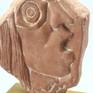 A form of a human head on special clay with white patina.
Mounted on a wooden base.