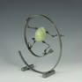 Egg is made from cast polymer resin. limbs are hand fabricated form copper tubes and wires. Articulable joints are made from copper disks with over 100 hand punched holes to capture desired posture, then sealed permanently with fixative. Figures are attached to the steel base with magnets.