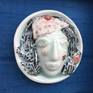 Handcrafted in porcelain with application of Celadon glaze and underglaze painting. A unique piece of art, fired at 1300 degree C.

The art work comes with an optional matt finish white wooden box frame and blue silk background.

Dimension with frame - 12 inch(H) x 12 inch(W) x 3 inch (Depth)
