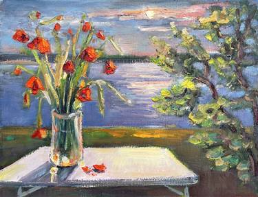 A bouquet of poppies against the background of an evening sunset over the river. thumb