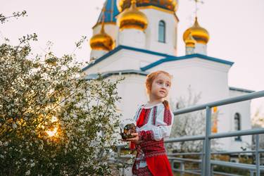 Girl in national Ukrainian suit near church for Easter holiday thumb