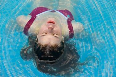 young woman relaxing in blue water thumb