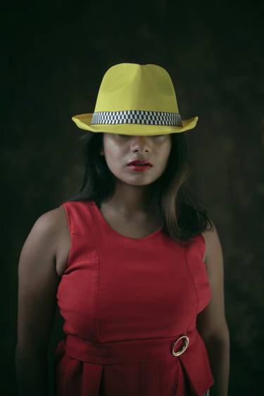 Mysterious young woman in red dress and yellow western hat thumb