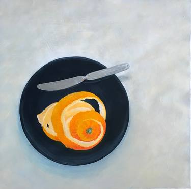 An orange peel and a knife on a balk dish. thumb