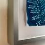 This piece is float mounted in a brushed silver designer frame with a depth of 1.5 inches.