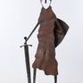 The steel sculpture "Knight on Guard" loosely follows my previous silhouette and figural stylizations. However, the overall tone is different both in the form of stylization of the body and the focus on the small details that are decisive for the artwork and which are characteristic of the image of a knight.
The theme itself, the figure of a knight on guard, is not an image of a warrior, but a knight for whom honor and pride were something for which he was willing to die. The theme is the guardian of honor, loyalty and honesty.
An old rusted sheet metal is used on the body, which is partially embossed so that the surface sculpture is completed by shadows. The other parts are forged.
The sculpture is signed on the base.