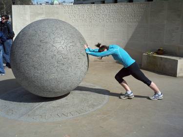 A jogger stretching  agaist a stone ball Whitehall London UK thumb