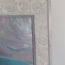 The frame is a white wooden ornate vintage looking frame which also has hints of subtle light grey.