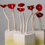 Several flowers bloom out of the solid cubes. The flower sculpted from Paper- matche and the cubes sculpted from clay