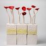 Several flowers bloom out of the solid cubes. The flower sculpted from Paper- matche and the cubes sculpted from clay