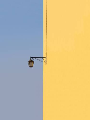 Single lamp on yellow wall thumb