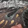 Created by making strokes with a stone brush using metallic acrylic paint