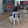 a visitor sits and watches the works at the exhibition