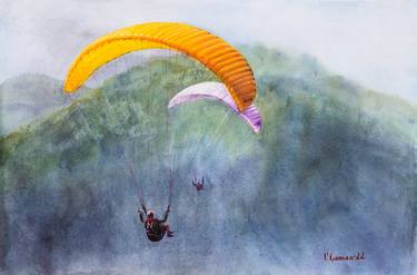 Two Paragliders hover over the mountains in a foggy haze. thumb