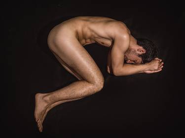 Birth. Exercise on male nude. Naked man on black thumb
