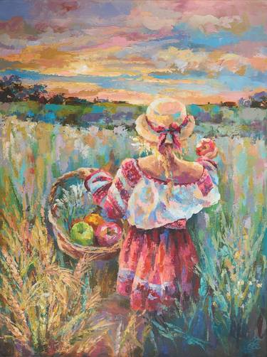 Ukrainian girl with apples in a wheat field at sunset thumb