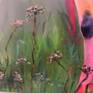 Multi colored cow standing in a bed of Angelica flowers