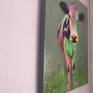 Multi colored cow standing in a bed of Angelica flowers