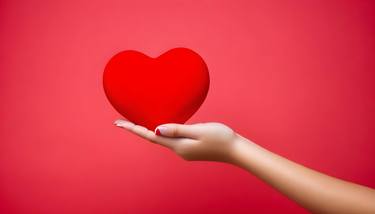 A woman are holding Red Heart with Red background. thumb