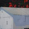 This acrylic work is painted on canvas and measures 19 x 26 inches. The white barn is clearly represented. We can see the peeling white planks on its sunlit surface. But the structure also appears to be dripping into abstraction towards the bottom foreground. Our eyes are drawn up to the focal point, the red sky between textured trees. This vibrant red sky compliments the more subtle blue we see  between the paint drips below. The contrasting dark and white areas define the painting’s composition.