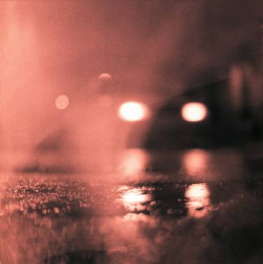 Analog photo of tarmac of street at night with car headlights in rain thumb