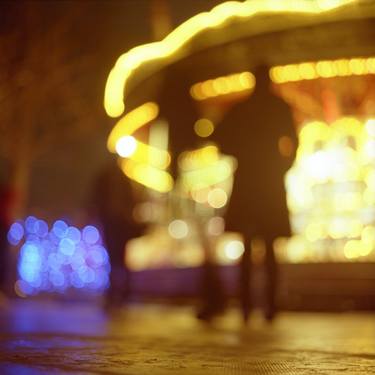 People walking in street at night with fairground lights in Hasselblad vintage camera analogue film photo thumb