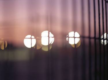 Bokeh lights through fence seen from train color analog medium format Mamiya 645 film photos thumb