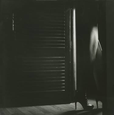 Film noir light through door young lady in heels black and white silver gelatin square analog photo thumb