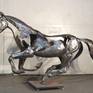 This work is by commission only and requires 2-3 months to make. 
This sculpture portraits the graceful energy of a horse galloping, frozen at the moment where one foot is on the ground and all others are in the air. This is a handmade, hammered and welded stainless steel sculpture.