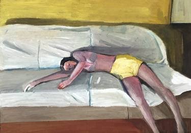 Young girl in yellow shorts lying on a sofa thumb