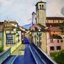 A mixed media painting - watercolour, watercolour pencil and stone tiny details are drawn by ink pen. Fresh early autumn morning in my beloved town in Friuli Venezia Giulia region, named Cividale del Friuli. This is the main street that runs through the town and long indigo blue shadows created by the morning sun fall on Ponte Del Diavolo. Underneath run turquoise waters of Natisone river.