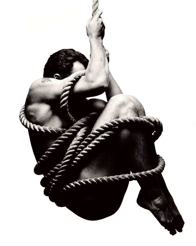 Man hanging from rope Photography by McVirn Etienne