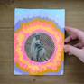 Unframed, frontal view with hand.