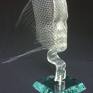 The sculpture was created after melting the strip of glass on a steel mesh (face). The sculpture is fastened with a steel holder to the glass base (self-assembly).