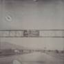 Other Desert Cities (Sidewinder) - 2005

160x175cm, Edition 1/5, 13 piece, 48x46cm each.
Analog C-Print, hand printed by the artist,  based on 13 Polaroids.
Signature label and Certificate.
Artist Inventory No. 3432A. 
Not mounted. 

2005  SIDEWINDER - Director / Artist  / Camera / Editing - starring JD Rudometkin, Stefanie Schneider, music by JD Rudometkin

private history turned into an intimate mythology of elemental fantasies where reality is perceived through a veil of psychedelic memories and unconscious projections. such is a collection of passions and dreams, an uncanny diary of ephemeral narratives and mental intensities in Stefanie Schneider’s painterly photographs where subjectivity of an ontological doubt uses a poetics of pastische as a vehicle for an intertextual journey towards the truth and the authenticity of primary emotions. here time is immersed in a nostalgic suspense of oneiric dimension, a sort of ambiguous coma of silence and comfort, and open space embraces a psychotic landscape of solitude and accidental pleasure. fetishisized surface of extreme feelings gives a stage for an unsolicited promise of unconditional love and unlimited freedom, a promise framed by sensual tension between fulfillment and expectation. (Adam Budak, Kunsthaus Graz, Oct 2005)

Sidewinder
There’s blood on the dress that hangs in the Airstream trailer outside 29 palms. With the pistol in her sweat palm touching at his temple. Tell me what god’s gonna do for me and you now Stevie’s saying while Brother John Baptiste looks there across to where her cat seems weak and fed. All the good that comes to me from my believing man, I wanna hear about it said to me like that. Just the way you breathed it like you did 10 minutes ago when I was wrapped so well around your head. Silence then. A baby screams his mother out in the dessert night who wakes so late. Orion is a belt John Baptiste looks at through the torn-screen trailer window. There, touching his calf are vipers crawling now across her feet between his knees in front of her he kneeling for his life and they are full of venom with their broken fangs.

A gun at head, where even his breath, so short, is preaching. He’s in a wheat field. John Baptiste. Counting birds on telephone wires hung low in afternoon where his mother’s call cannot now reach him. There she stands a weeping willow with the sidewinder underneath the trailer step a drop of blood upon her ankle with the bullet through its head. A scar follows sweat palm to wrist. Torn Stevie. Scars from the weapon to her toes an accidental act of God her father said. On Vaness at California 16 years ago but who’s counting 6 bullets for the barrel wait beside the temple. The long white shaft of tissue hemmed together gods tattoo along her ribs, hip to breast. She wants to fuck the preacher in her trailer with his bible on the alter front row Stevie asks forgiveness holy father from the car that shook her bones apart. John Baptiste asks to pray before she leads his temple head.

For twenty minutes darkness hides the accidents in trailer shade her childish screams a preacher underneath her shimmer blue bled dress. The prayers he said beside the bed with mother for relatives with tumors, brand new bicycles, and rain. Stevie takes the whisky in her mouth to wash him out the sidewinder skids across her wounded foot of scars. John Baptiste asks the Lord to heal her in the new day that is breaking mouth of whisky spits it laughing father forgive the trigger finger for the viper he gives thanks.

And takes the barrel toward his lips through mumbling supplication kiss it Brother Stevie offers, please, but doesn’t wait him there. Copper penny Sunday School upon the tongue. And closed his eyes. A blur of her and mother. Other bodies. Women, gently crushing spirits. Prayers. His han under her weight in grams. The fingernail fang and fucks it. So slid the pull of metal out As god can answer. And into her mouth then. Settles. And wet the metal. He touches her, his finger. Viper like. And fuck it sore. Believers. Repentant whore forgiven preacher leaving town in that old ragtop down and left a rag dress bleeding in the Airstream soft, again. (JD Rudometkin)

“Working on Sidewinder with Stefanie Schneider was intense. It is a very personal piece for both of us, though I feel in very different ways. When overdue fears and aspirations are able to surface in a project, the work becomes a mirror. Such efforts are always a risk. I am still uncertain of what exactly to make of it Sidewinder. How much should have been exposed. What needs to remain sacred. I almost did not drive that „68 Deville” out to 29 Palms on the day we were set to shoot. I followed her out there against a feeling I had. Was it fear? I don’t know. Perhaps mistakes do not exist. What is our intuition composed of anyhow? When I look out across the desert, it seems so flat. So free of dramatic lines. That is when a human figure appears, even in the distance, a curiosity. There are so many of us clustered in these cities, who would care. Why take the time? I will always drive out of town back into parts of Sidewinder from time to time.”(JD Rudometkin)

------

In the case of Sidewinder the scenario was created by internet where she met J.D. Rudometkin, an ex-theologian, who agreed to her idea to live with her for five weeks in the scrubland desert
environment of Southern California. The dynamics and unfolding of their relationship, both sexually and emotionally, became the primary subject matter of this series of photographs. The relative isolation and their close proximity, the interactive tensions, conflicts and submissions, are thus recorded to reveal the day-to-day evolution of their relationship. That a time limit was set on this relation-based experiment was not the least important aspect of the project. The text and music accompanying the DVD were written by the American Rudometkin, who speaks poetically of “Torn Stevie. Scars from the weapon to her toes an accidental act of God her father said. On Vaness at California.” The mix of hip reverie and fantasy-based language of his text, echoes the chaotic unfolding of their daily life in this period, and is evident in the almost sun-bleached Polaroid images like Whiskey Dance, where the two abandon themselves to the frenetic circumstances of the moment. Thus Sidewinder, a euphemism for both a missile and a rattlesnake, hints at the libidinal and emotional dangers that were risked by Schneider and Rudometkin. Perhaps, more than any other of her photo-novels it was the most spontaneous and immediate, since Schneider’s direct participation mitigated against and narrowed down the space between her life and the art work. The explicit and direct character of their relationship at this time, opens up the question as to the biographical role Schneider plays in all her work. She both makes and directs the work while simultaneously dwelling within the artistic processes as they unfold. Hence she is both author and character, conceiving the frame within which things will take place, and yet still subject to the same unpredictable outcomes that emerge in the process.

(Mark Gisbourne, Stranger than Paradise, 2006, page 12-14)