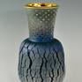 This elegant vase is inspired by the painting "Starry night' by Van Gogh. It was thrown with a hard to master technique that causes the fissures in the surface. The perforations in the neck are accentuated with gold. The inside of the neck is also covered with a layer of shiny gold luster to create a strong contrast with the weathered dark blue surface of this piece. As soon as light falls on the dark blue vase the impression is created that light is glowing from the inside.